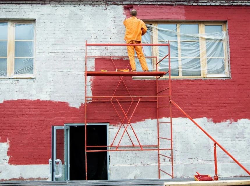 pintores de reus pintando una fachada de rojo